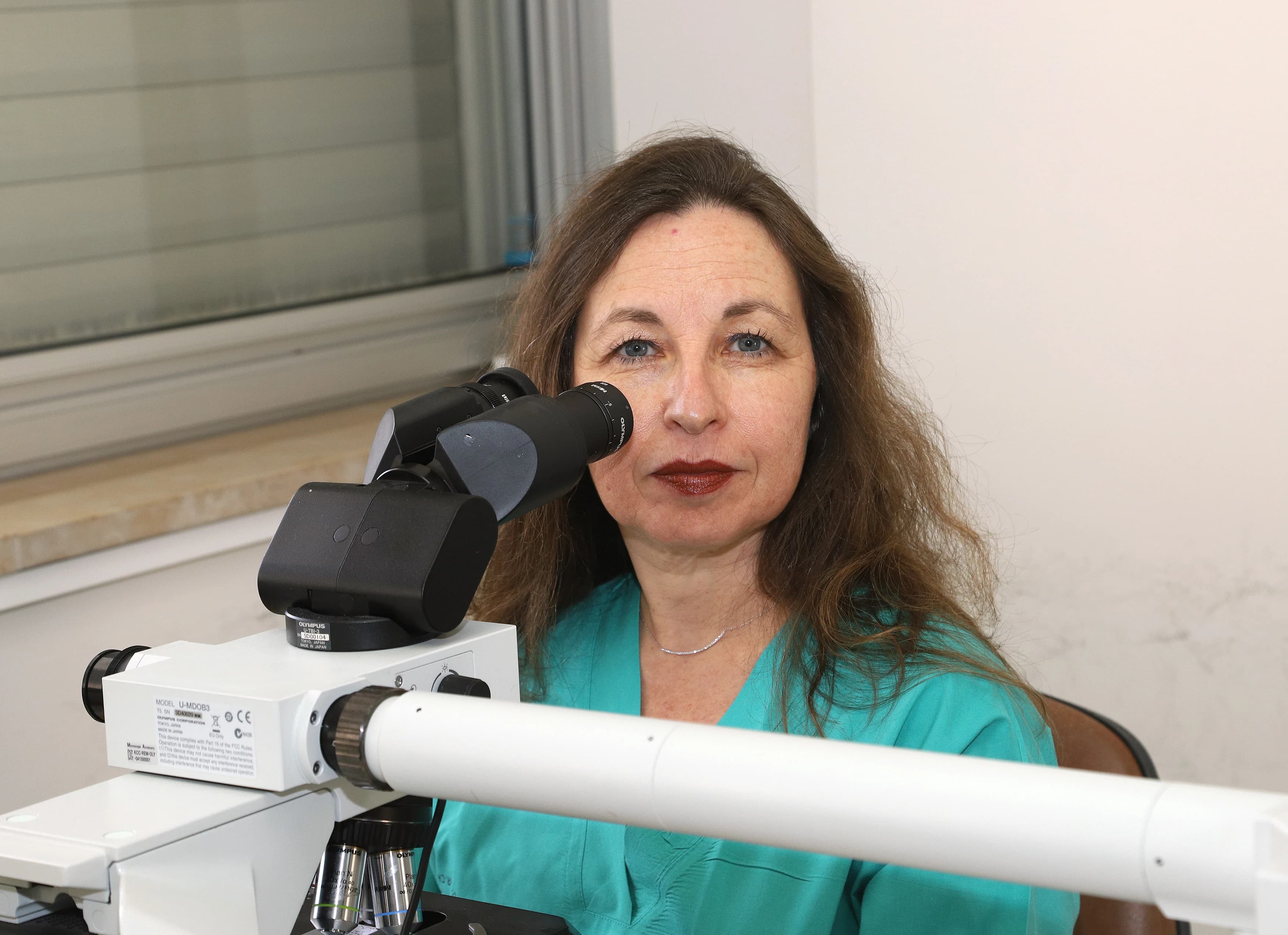 ד"ר אבינועם-דר בודקת רקמה במיקרוסקופ במהלך ניתוח מוהס